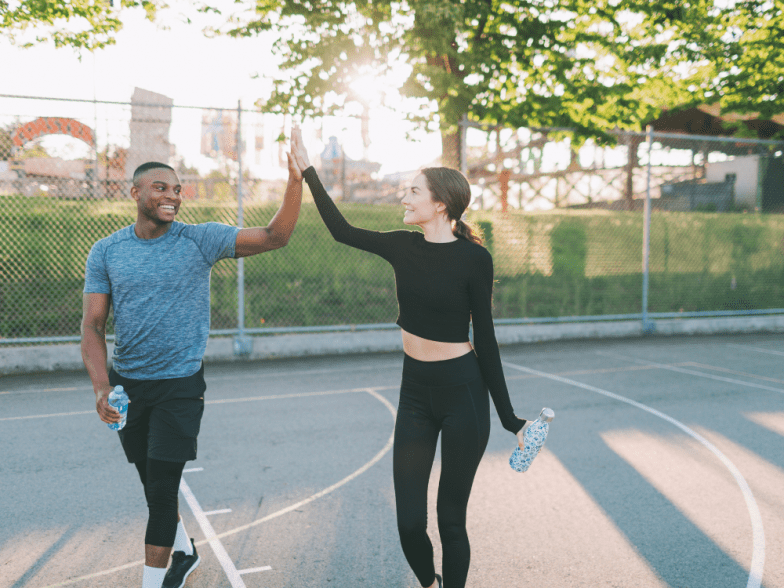 Man and women highfive in workout attire