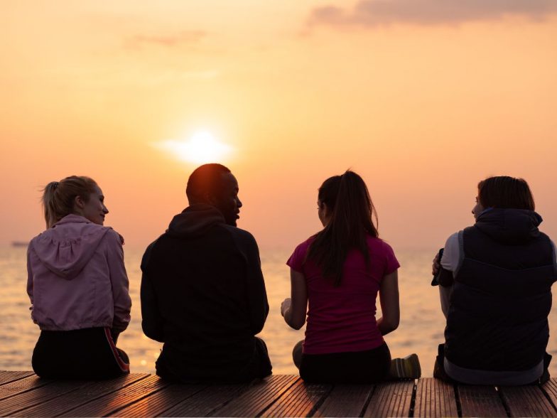 4 friends sitting watching a sunset